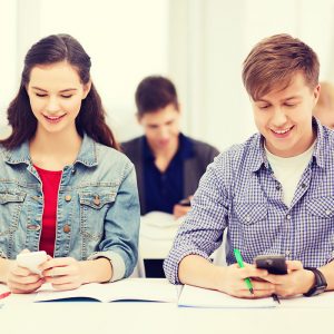 students looking into smartphone at school